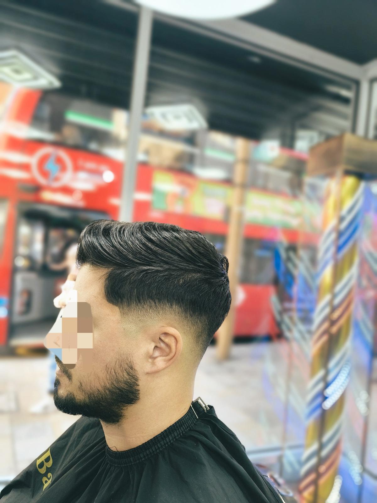 Barber with a client after a cut, in the shop